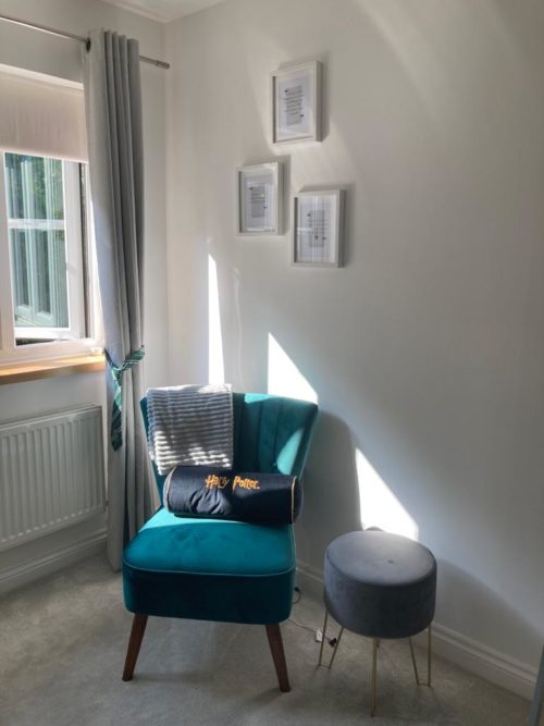 Green chair and grey footstool in window