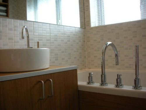 Oak vanity unit with modern sink, bath and taps