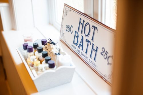 Window sill with hot bath sign and basket of toiletries