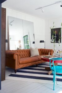 How to make small rooms appear larger, use of mirrors, lounge with leather sofa and large mirror