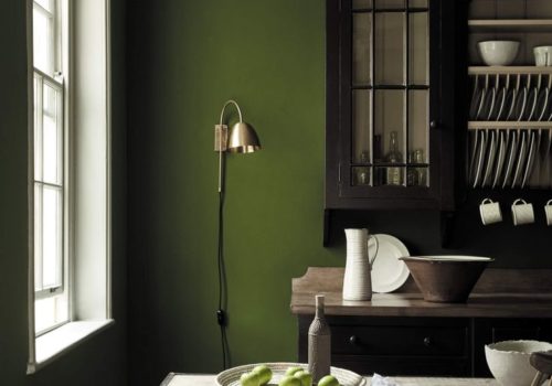 Olive Green Paint from Little Green in a kitchen with a dresser unit and floor lamp